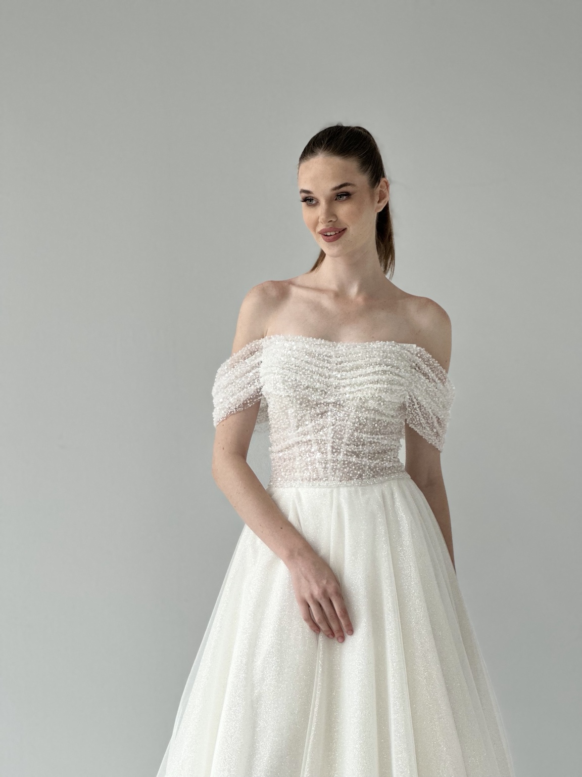 Pearl-draped off-the-shoulder bridal gown by Atelier Areno